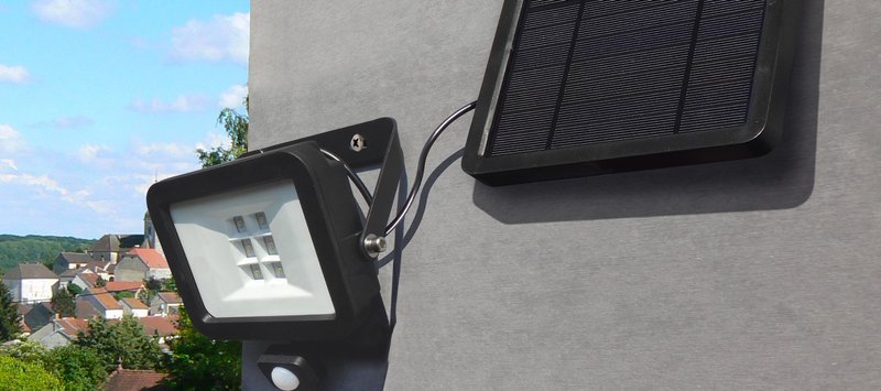 Applique avec écran solaire accrochée à une façade de maison vue de jour