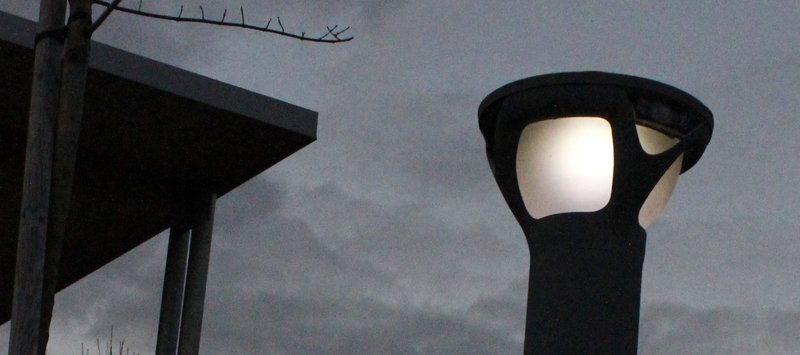 Petit lampadaire allumé à la tombée de la nuit