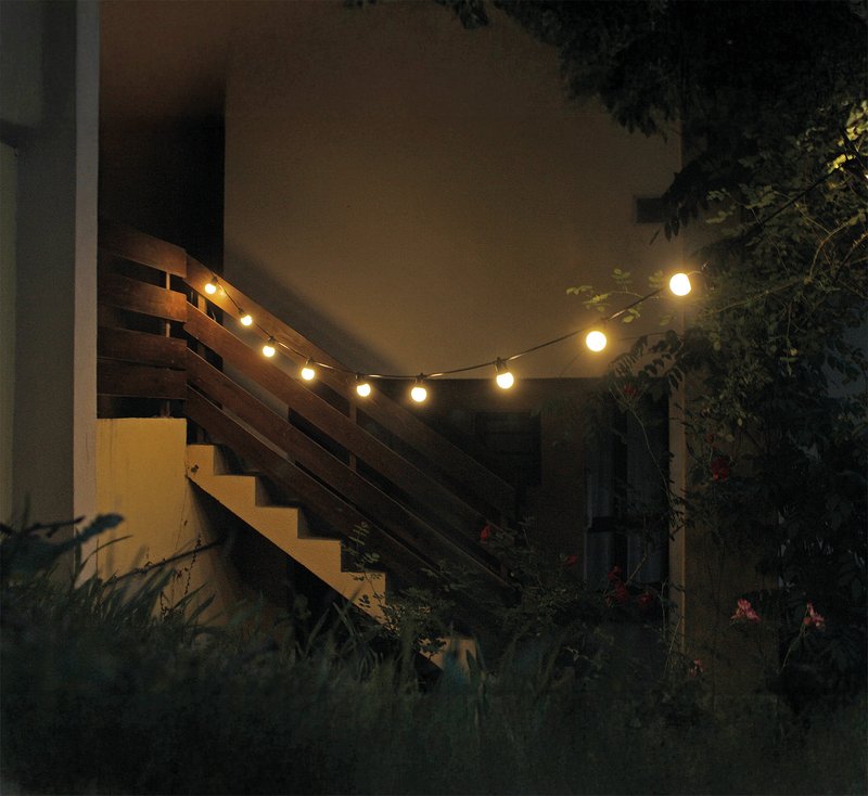 Guirlande solaire de grandes ampoues dans une montée d'escalier extérieur