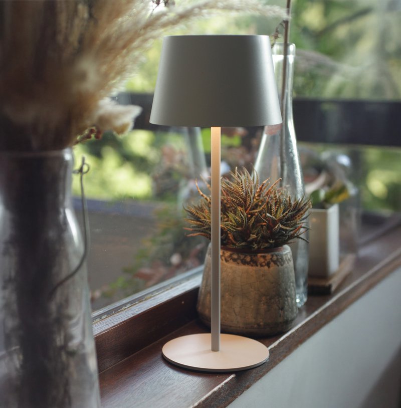 Petite lampe solaire posée sur un rebord de fenêtre