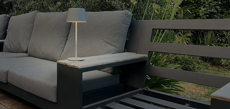 Une lampe solaire posée sur l'accoudoir d'un canapé de terrasse