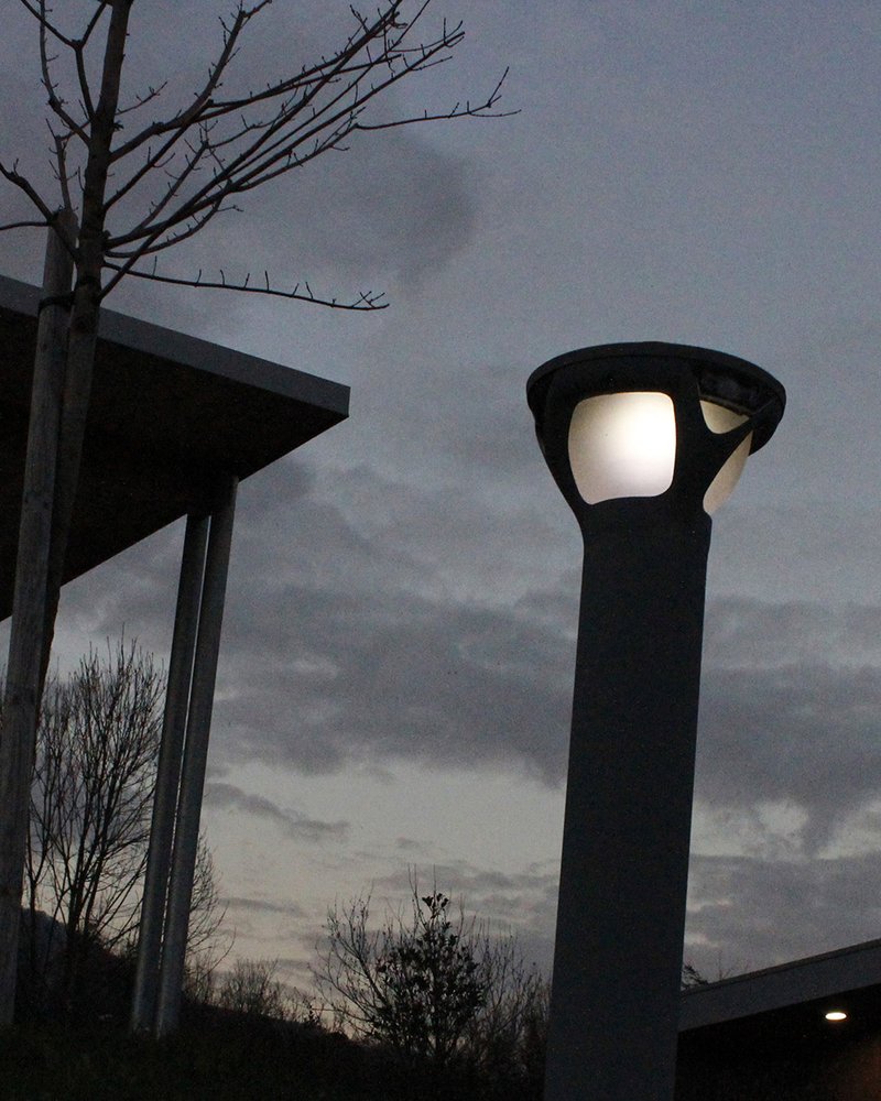 Petit lampadaire allumé à la tombée de la nuit